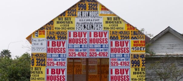 Photo of a house with I buy houses signs